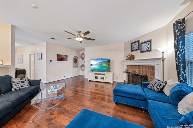 living room featuring dark hardwood / wood-style floors, ceiling fan, and a fireplace