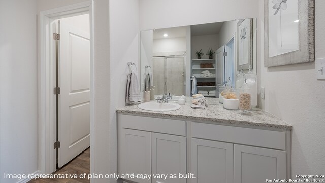 bathroom with vanity and a shower with shower door
