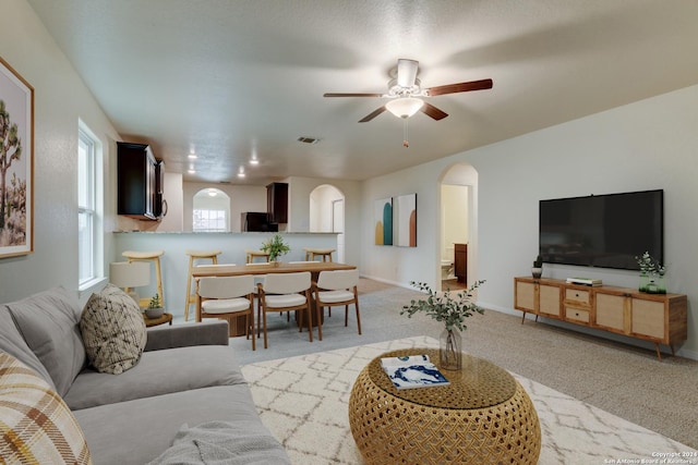 living room with ceiling fan and light colored carpet