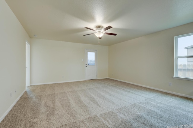 carpeted spare room with ceiling fan