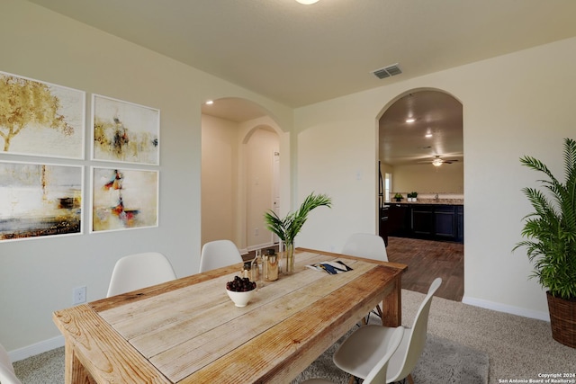 carpeted dining space with ceiling fan