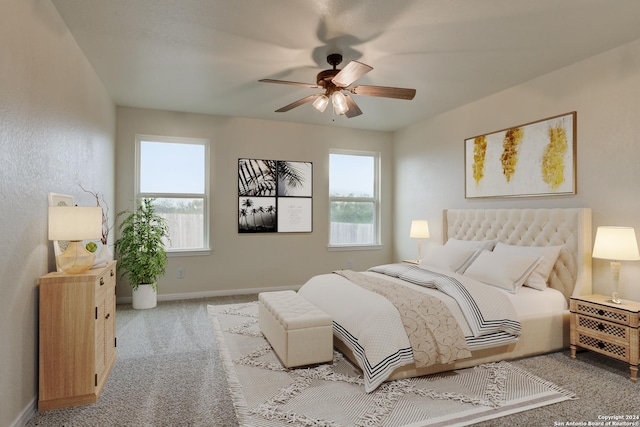 bedroom with ceiling fan, carpet floors, and multiple windows