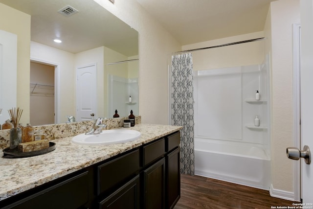 bathroom featuring vanity, shower / bathtub combination with curtain, and wood-type flooring