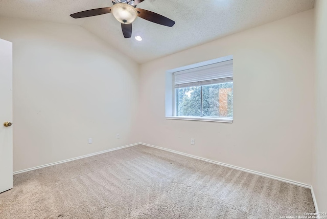 carpeted empty room featuring a textured ceiling, ceiling fan, and lofted ceiling