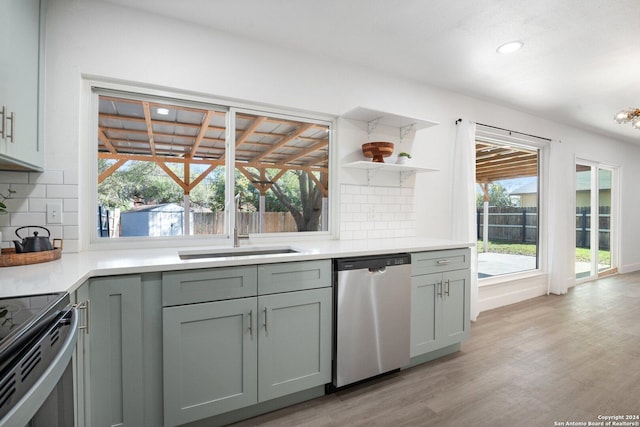 kitchen with backsplash, gray cabinetry, stainless steel appliances, sink, and light hardwood / wood-style flooring