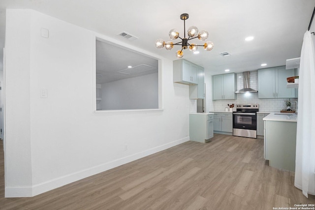 kitchen with pendant lighting, light hardwood / wood-style floors, stainless steel electric range oven, and wall chimney range hood