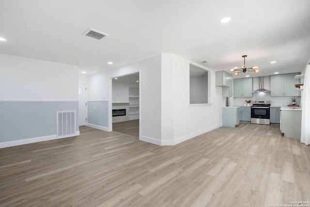 unfurnished living room featuring light hardwood / wood-style floors and a notable chandelier