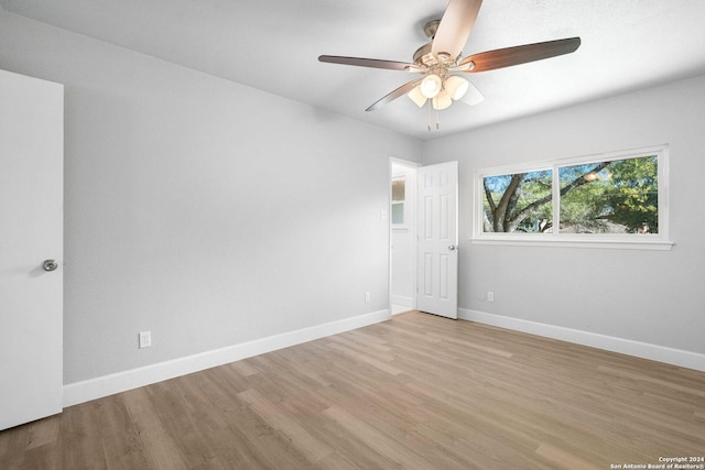 spare room with ceiling fan and light wood-type flooring