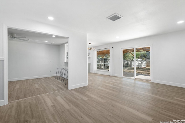 interior space featuring light hardwood / wood-style floors and ceiling fan with notable chandelier