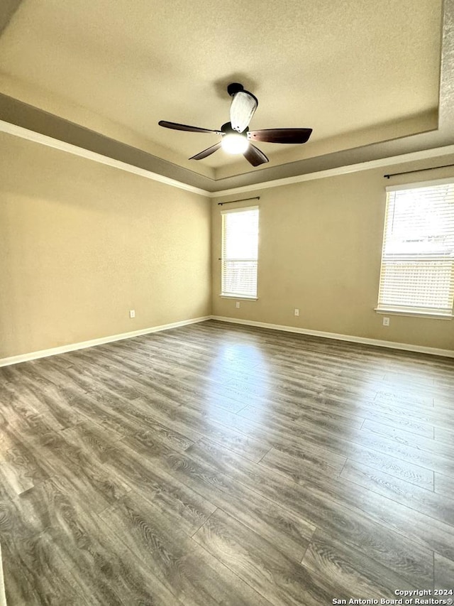 spare room featuring hardwood / wood-style floors, a textured ceiling, a tray ceiling, and ceiling fan