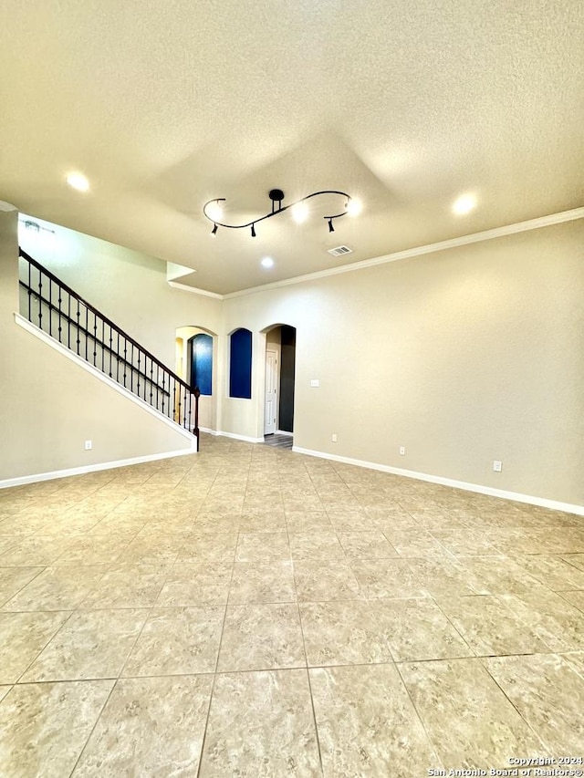 unfurnished living room featuring a textured ceiling and ornamental molding