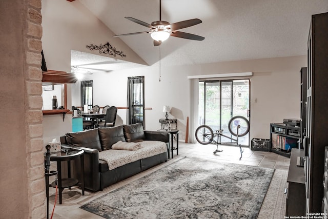 living room featuring ceiling fan, light tile patterned flooring, a textured ceiling, and high vaulted ceiling