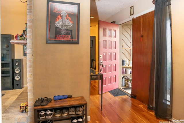 foyer entrance featuring hardwood / wood-style floors and a textured ceiling