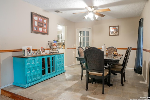 dining space with ceiling fan and a textured ceiling