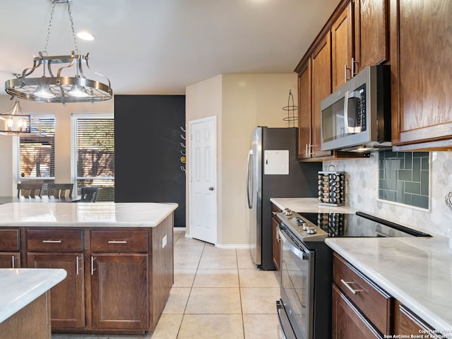 kitchen featuring pendant lighting, a chandelier, decorative backsplash, light tile patterned floors, and appliances with stainless steel finishes