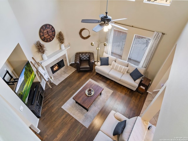 living room featuring a tile fireplace, a high ceiling, and dark wood-type flooring