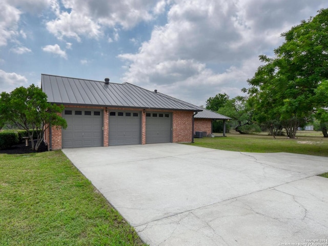 view of front of property with central air condition unit, a front yard, and a garage