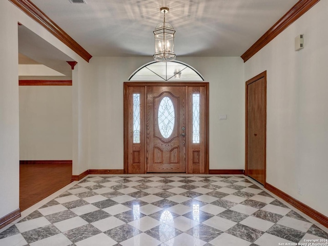 entryway featuring ornamental molding and an inviting chandelier