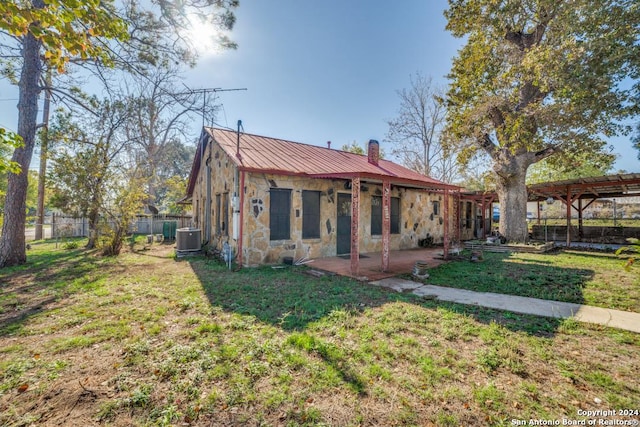 view of front of home with central air condition unit and a front lawn