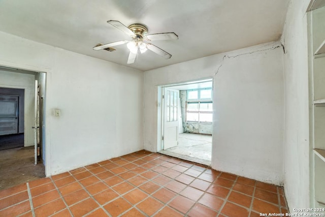 tiled empty room featuring ceiling fan