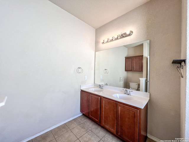 bathroom featuring tile patterned flooring, a textured ceiling, vanity, and toilet