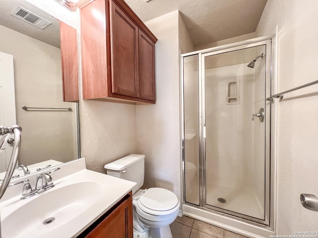 bathroom featuring tile patterned flooring, vanity, a textured ceiling, and walk in shower