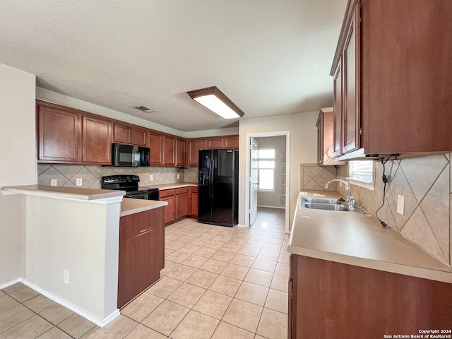 kitchen with kitchen peninsula, tasteful backsplash, sink, black appliances, and light tile patterned flooring