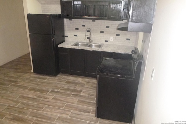 kitchen with black appliances, decorative backsplash, light hardwood / wood-style floors, and sink