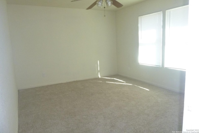 carpeted spare room with ceiling fan