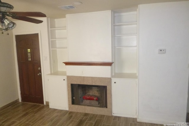 unfurnished living room with ceiling fan, a fireplace, and wood-type flooring