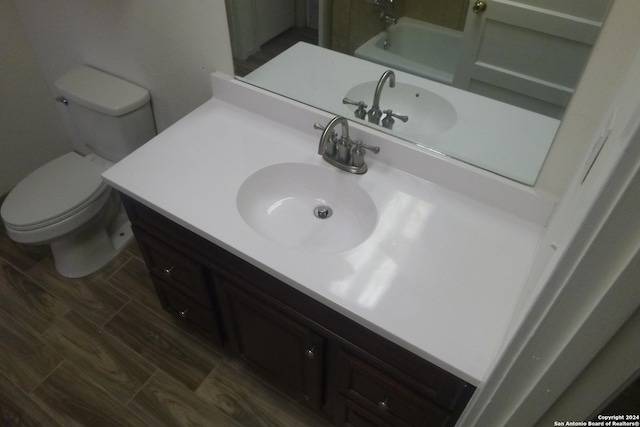 full bathroom with vanity, toilet, wood-type flooring, and plus walk in shower