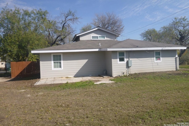 rear view of property featuring a yard