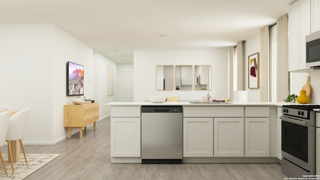 kitchen featuring kitchen peninsula, appliances with stainless steel finishes, sink, light hardwood / wood-style flooring, and white cabinetry