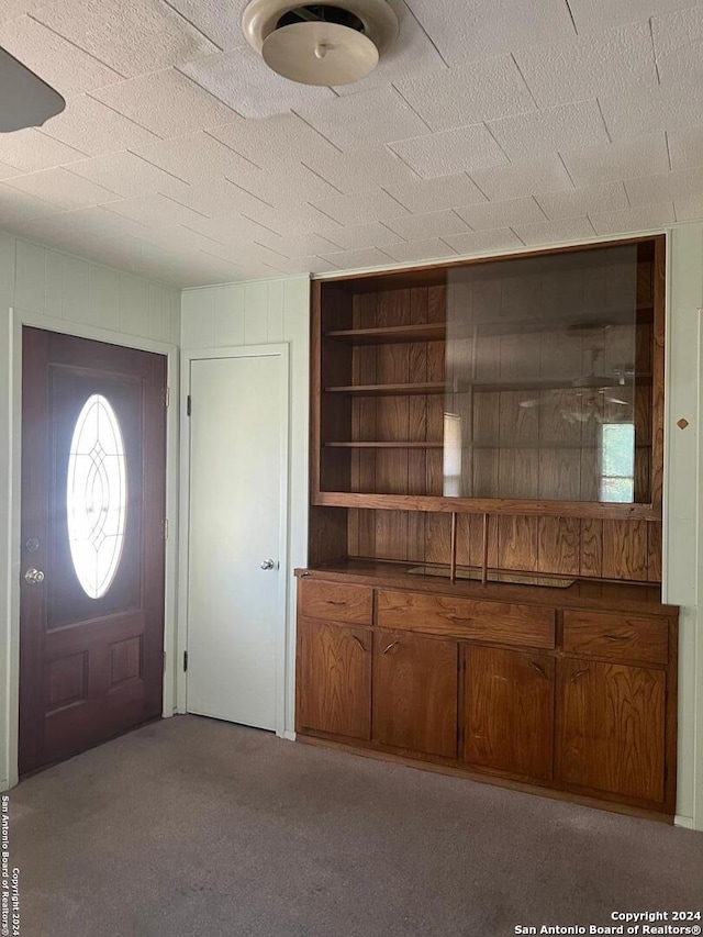 entryway featuring a textured ceiling and light carpet