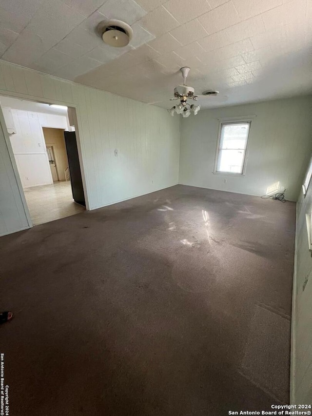 carpeted empty room featuring ceiling fan