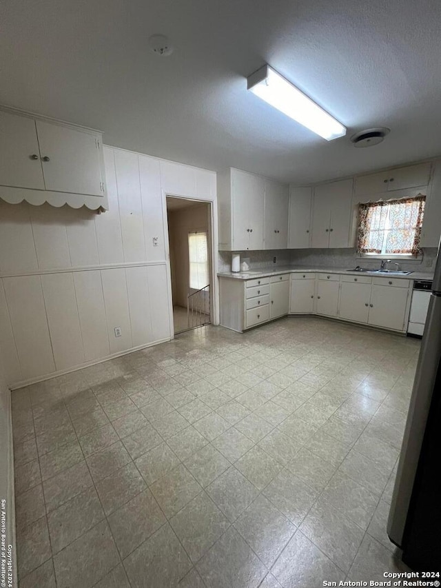 kitchen featuring white cabinets, dishwasher, and sink