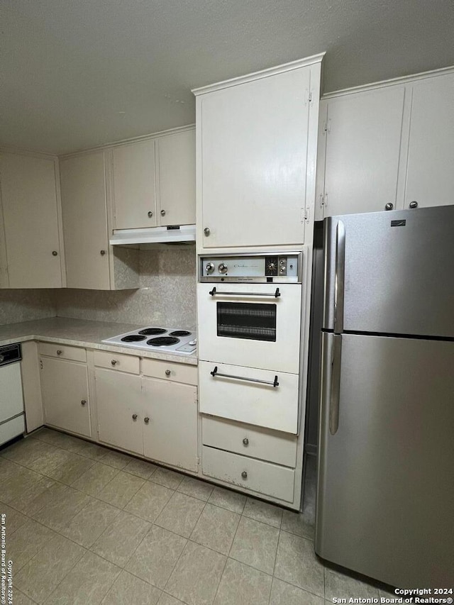 kitchen featuring white cabinets, white appliances, and backsplash