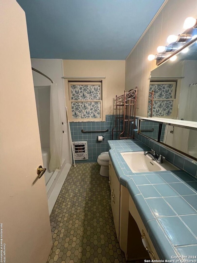 full bathroom featuring heating unit, toilet, vanity, shower / tub combo, and ornamental molding