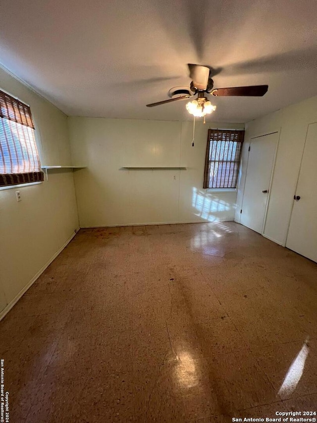 spare room with ceiling fan and plenty of natural light