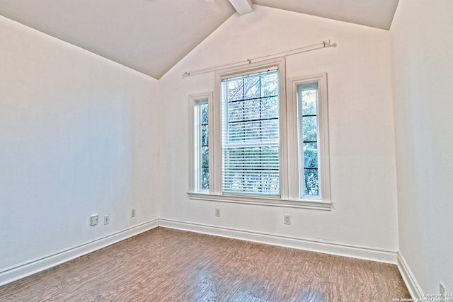 empty room with vaulted ceiling with beams and hardwood / wood-style flooring