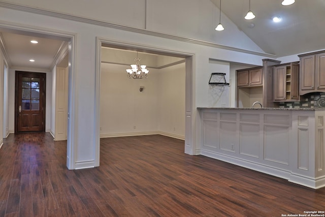 kitchen featuring dark wood-type flooring, high vaulted ceiling, crown molding, light stone countertops, and a chandelier