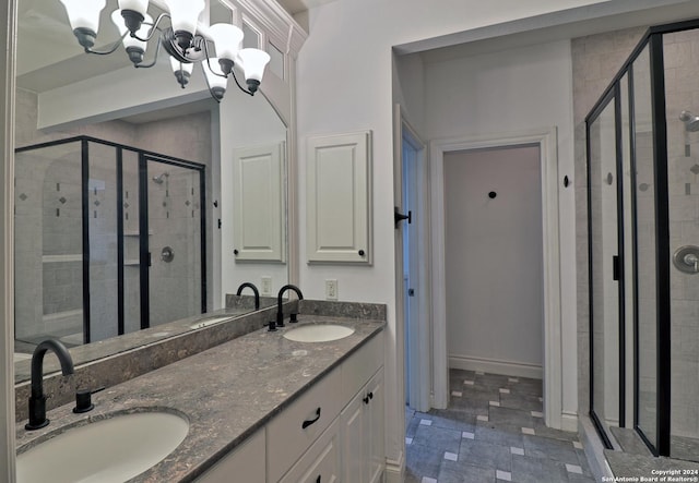 bathroom featuring a chandelier, vanity, and a shower with shower door