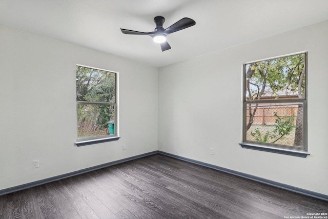 empty room with ceiling fan, dark hardwood / wood-style flooring, and a healthy amount of sunlight