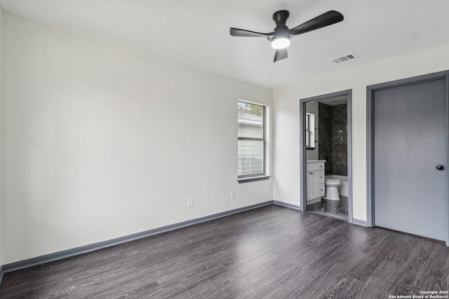 unfurnished bedroom featuring dark hardwood / wood-style floors, ceiling fan, and connected bathroom