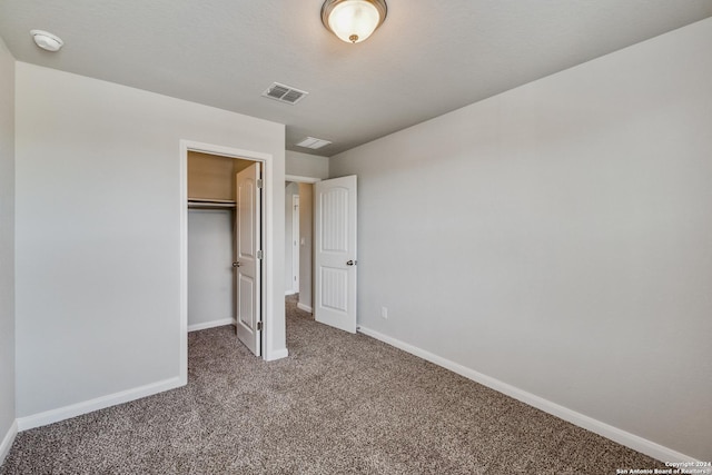 unfurnished bedroom featuring a spacious closet, a closet, and carpet floors