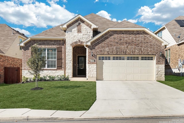 front facade featuring a garage and a front yard