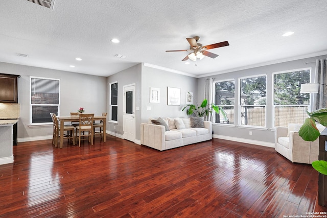 living room featuring a textured ceiling, ceiling fan, ornamental molding, and dark wood-type flooring