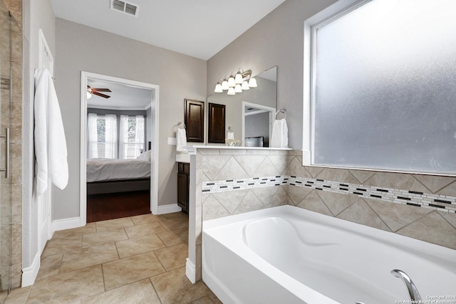 bathroom featuring tile patterned floors, a bathtub, ceiling fan, and vanity