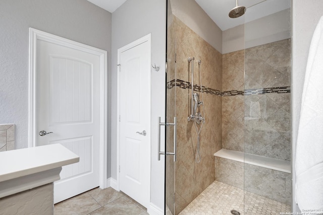 bathroom featuring tile patterned floors and tiled shower