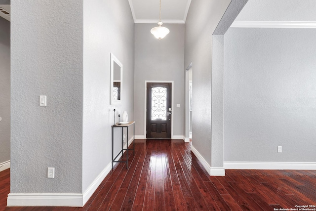 foyer entrance with dark hardwood / wood-style flooring and ornamental molding